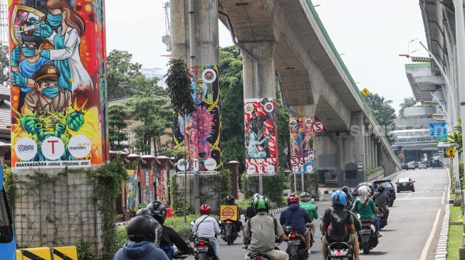 Kendaraan melintasi Jalan Layang Non Tol Transjakarta (JLNT) yang dihiasi mural di Jalan Trunojoyo, Jakarta Selatan, Sabtu (6/11/2021). [Suara.com/Alfian Winanto]