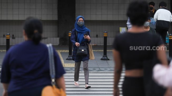 Warga beraktivitas di Jalan Sudirman, Jakarta Pusat, Sabtu (6/11/2021). [Suara.com/Alfian Winanto]