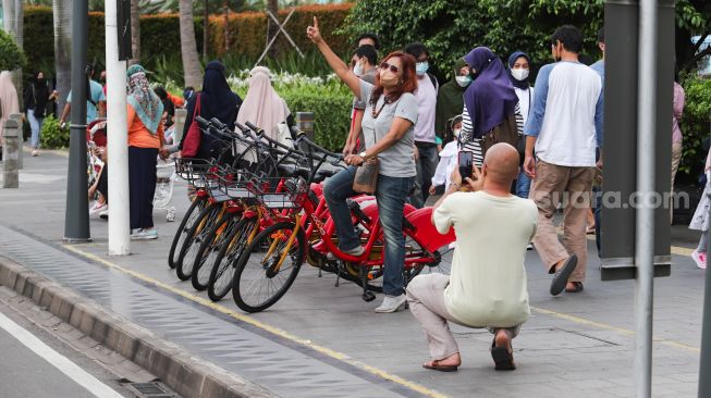 Warga beraktivitas di Jalan Sudirman, Jakarta Pusat, Sabtu (6/11/2021). [Suara.com/Alfian Winanto]