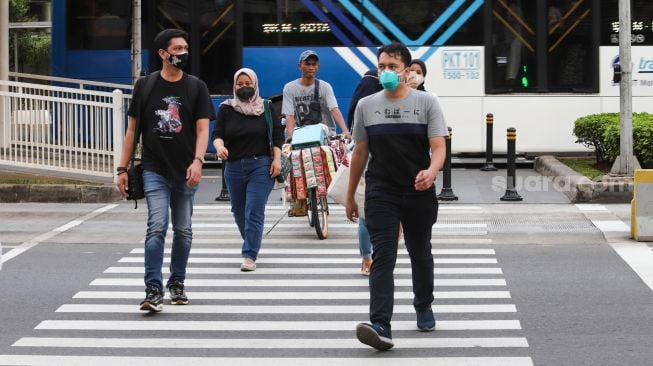 Warga beraktivitas di Jalan Sudirman, Jakarta Pusat, Sabtu (6/11/2021). [Suara.com/Alfian Winanto]