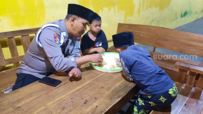 Bripka Ali Suwandhi ikut makan bersama dengan anak asuhnya di Rumah Singgah Bumi Damai, Jalan Purbayan, Kemantren Kotagede, Kota Jogja, Minggu (7/11/2021). - (SuaraJogja.id/Muhammad Ilham Baktora)