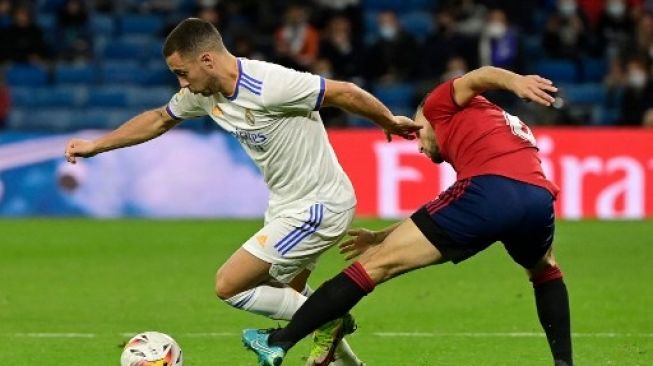 Pemain Real Madrid Eden Hazard mencoba melewati pemain Osasuna dalam pertandingan La Liga di Santiago Bernabeu pada 27 Oktober 2021. [AFP]