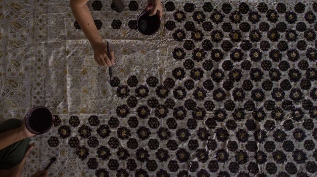 Pekerja menyelesaikan pembuatan kain batik cap khas Palembang di rumah produksi Eka Marlina di Palembang, Sumatera Selatan, Senin (8/11/2021). [ANTARA FOTO/Nova Wahyudi]