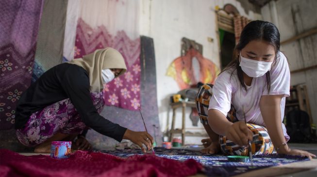 Pekerja menyelesaikan pembuatan kain jumputan di rumah produksi Eka Marlina di Palembang, Sumatera Selatan, Senin (8/11/2021). [ANTARA FOTO/Nova Wahyudi]