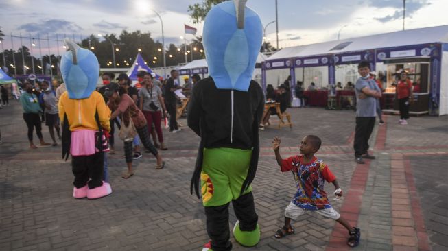 Seorang anak bermain dengan maskot Peparnas saat Festival Peparnas Papua yang digelar di Kompleks Stadion Lukas Enembe, Kabupaten Jayapura, Papua, Senin (8/11/2021). [ANTARA FOTO/Raisan Al Farisi]