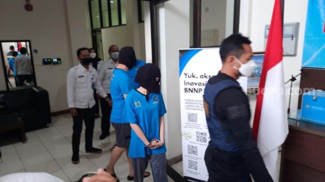 Tersangka kasus peredaran sabu di sebuah spa di Jalan Magelang, Sleman digelandang petugas saat konferensi pers di Kantor BNNP DIY,  Kota Jogja, Senin (8/11/2021). - (SuaraJogja.id/Muhammad Ilham Baktora)