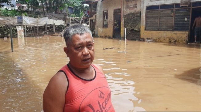 Kawasan Rawajati, Pancoran Jakarta Selatan, masih direndam banjir setinggi 20-40 sentimeter. Warga di Jalan Bina Warga Rukun Tetangga (RT) 03 RW 07 berupaya mengurai genangan, Senin (8/11/2021). [Antara/Sihol Hasugian]