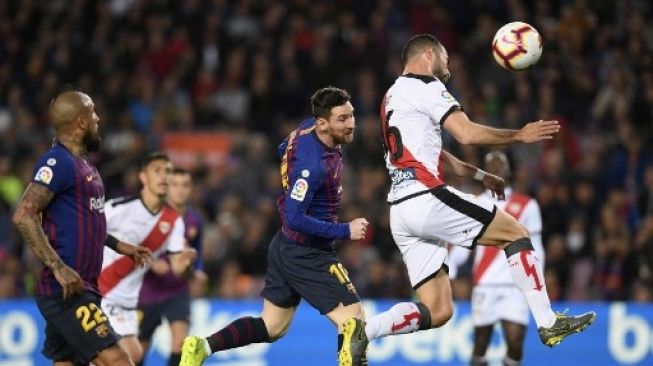 Jordi Amat, saat memperkuat Rayo Vallecano, berebut bola dengan pemain Barcelona Lionel Messi dalam pertandingan La Liga pada 3 November 2018. [AFP]