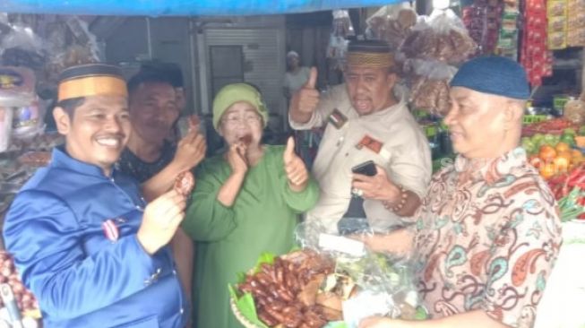 Pedagang dan Pengunjung Pasar Kota Makassar Minum Kopi dan Makan Kue Taripang