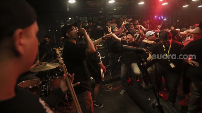 Penonton berselancar di keramaian atau‘crowd surfing’saat menyaksikan penampilan salah satu band dalam acara musik South Fest #2 di Jakarta, Minggu (10/10/2021). [Suara.com/Angga Budhiyanto]