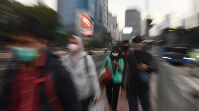 Pekerja menyeberang di pelican cross Tosari saat jam pulang kerja di Jakarta, Senin (8/11/2021). ANTARA FOTO/Indrianto Eko Suwarso