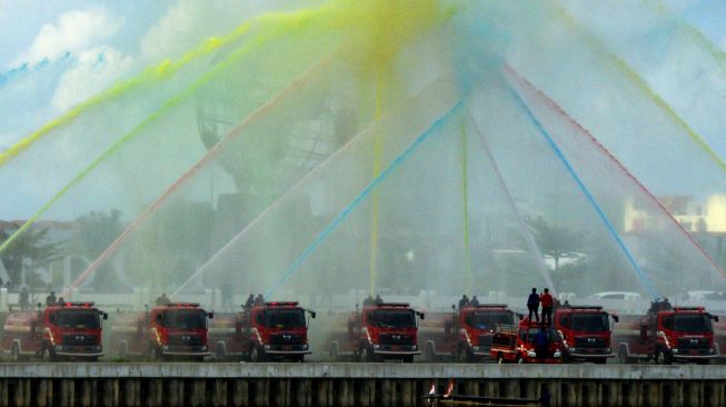 Petugas pemadam kebakaran melakukan atrkasi menyemprotkan air berwarna di Center Point of Indonesia (CPI), Makassar, Sulawesi Selatan, Selasa (9/11/2021). ANTARA FOTO/Abriawan Abh