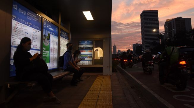 Pekerja menunggu kendaraan saat jam pulang kerja di Halte Summitmas, Jakarta, Senin (8/11/2021). ANTARA FOTO/Indrianto Eko Suwarso