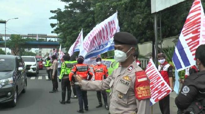 Polisi mengawal aksi unjuk rasa yang digelar FSPMI Kota Depok di depan Balaikota Depok, Rabu (10/11/2021). [Suarabogor.id/Immawan]