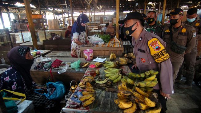 Petugas Satgas COVID-19 berbincang dengan pedagang saat melakukan razia warga yang belum divaksin COVID-19 di Pasar Bandung, Tegal, Jawa Tengah, Kamis (11/11/2021). ANTARA FOTO/Oky Lukmansyah