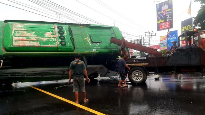 Kecelakaan bus terguling di Jalan Ring Road Barat, Demak Ijo, Kabupaten Sleman pada Kamis (11/11/2021) pagi. [Hiskia Andika Weadcaksana / SuaraJogja.id]