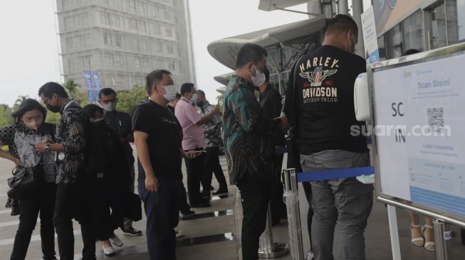 Pengunjung memindai kode batang dari aplikasi PeduliLindungi sebelum memasuki area pameran otomotif GAIKINDO Indonesia International Auto Show (GIIAS) 2021 di Indonesia Convention Exhibition (ICE) BSD, Serpong, Tangerang, Banten, Kamis (11/11/2021). [Suara.com/Angga Budhiyanto]