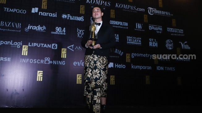 Aktor Jerome Kurnia berfoto setelah meraih penghargaan Pemeran Pendukung Pria Terbaik dalam gelaran Festival Film Indonesia di JCC Senayan, Jakarta Pusat, Rabu (10/11/2021). [Suara.com/Alfian Winanto]