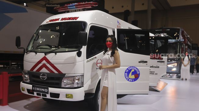 Model berpose di samping kendaraan yang dipamerkan dalam pameran otomotif GAIKINDO Indonesia International Auto Show (GIIAS) 2021 di Indonesia Convention Exhibition (ICE) BSD, Serpong, Tangerang, Banten, Kamis (11/11/2021). [Suara.com/Angga Budhiyanto]