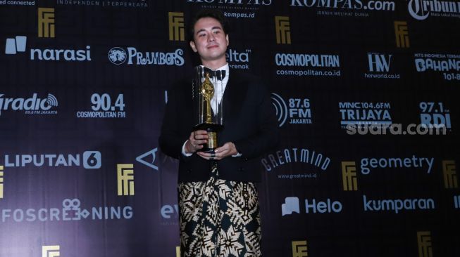 Aktor Jerome Kurnia berfoto setelah meraih penghargaan Pemeran Pendukung Pria Terbaik dalam gelaran Festival Film Indonesia di JCC Senayan, Jakarta Pusat, Rabu (10/11/2021). [Suara.com/Alfian Winanto]