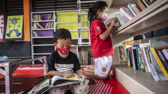 Anak-anak membaca buku di Bale Buku Jakarta, Dukuh, Jakarta Timur, Jumat (12/11/2021).  ANTARA FOTO/Aprillio Akbar