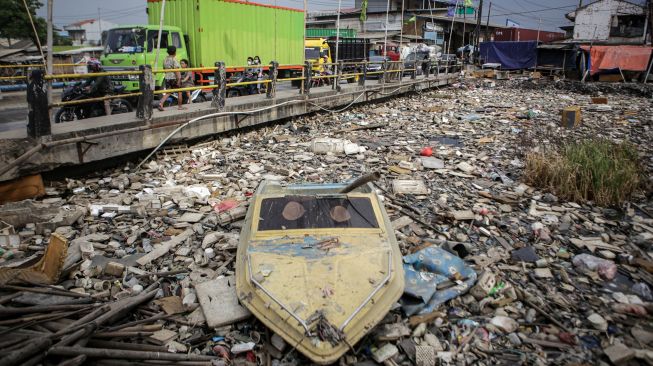 Sejumlah kendaraan melaju di samping sampah yang menumpuk di Kali Dadap yang dipenuhi sampah di Kosambi, Kabupaten Tangerang, Banten, Jumat (12/11/2021).  ANTARA FOTO/Fauzan