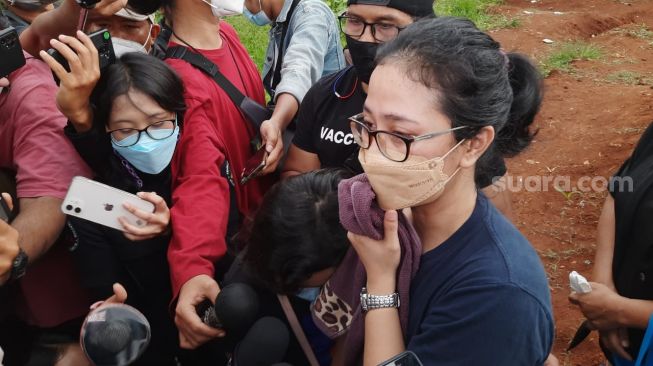 Istri Rony Dozer, Dina Mediana Kurniawati usai acara pemakaman sang suami di TPU Jombang, Tangerang Selatan, Jumat (12/11/2021). [Muhammad Anzar Anas/Suara.com]