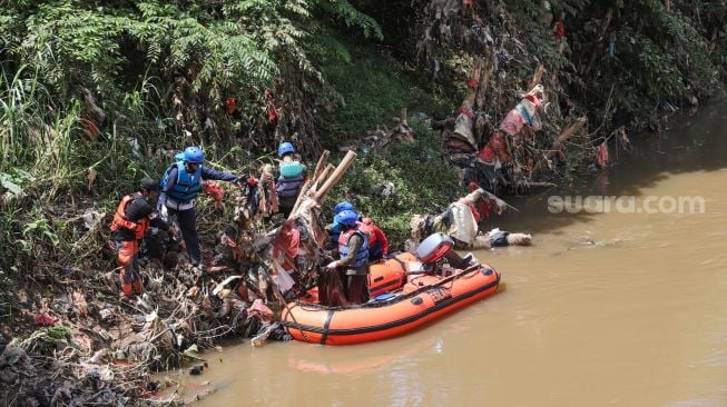 Anggota Forum Alumni Sispala DKI Jakarta (FASTA) berkolaborasi dengan Sekolah Sungai Jakarta (SSJ) dan Siswa Pencinta Alam (Sispala) membersihkan sungai di Bantaran Kali Ciliwung, Jakarta Selatan, Minggu (14/11/2021). [Suara.com/Alfian Winanto]