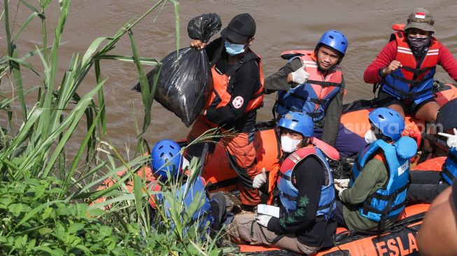 Anggota Forum Alumni Sispala DKI Jakarta (FASTA) berkolaborasi dengan Sekolah Sungai Jakarta (SSJ) dan Siswa Pencinta Alam (Sispala) membersihkan sungai di Bantaran Kali Ciliwung, Jakarta Selatan, Minggu (14/11/2021). [Suara.com/Alfian Winanto]