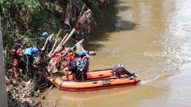 Anggota Forum Alumni Sispala DKI Jakarta (FASTA) berkolaborasi dengan Sekolah Sungai Jakarta (SSJ) dan Siswa Pencinta Alam (Sispala) membersihkan sungai di Bantaran Kali Ciliwung, Jakarta Selatan, Minggu (14/11/2021). [Suara.com/Alfian Winanto]