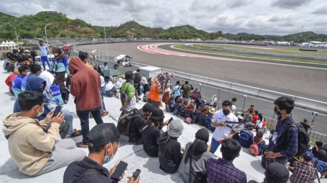 Sejumlah penonton berada di tribun sisi barat sirkuit untuk menonton gelaran balap motor Idemitsu Asia Talent Cup (IATC) di Pertamina Mandalika International Street Circuit di KEK Mandalika, Praya, Lombok Tengah, NTB, Sabtu (13/11/2021). .ANTARA FOTO/Ahmad Subaidi/aww.