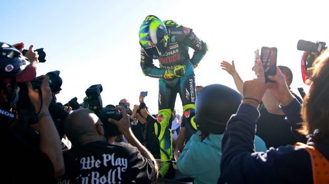 Fans pebalap Italia Valentino Rossi bersorak dari tribun selama balapan MotoGP Grand Prix Valencia di arena pacuan kuda Ricardo Tormo di Cheste, pada 14 November 2021. JOSE JORDAN / AFP