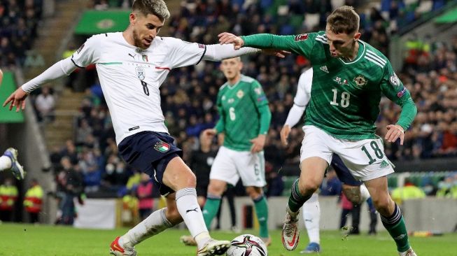 Gelandang Italia Jorginho berebut bola dengan pemain Irlandia Utara Gavin Whyte di laga terakhir kualifikasi Piala Dunia 2022. (foto: AFP)