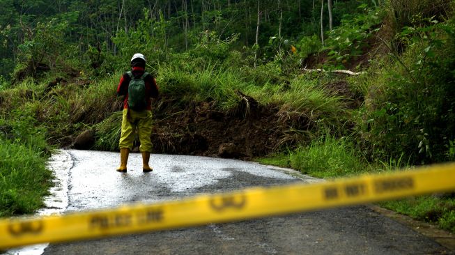 Petugas TRC BPBD D.I Yogyakarta melihat kondisi jalan Gunung Kelir-Kutogiri yang tertutup material tanah longsor di Perbukitan Menoreh, Girimulyo, Kulon Progo, D.I Yogyakarta, Selasa (16/11/2021).  ANTARA FOTO/Andreas Fitri Atmoko