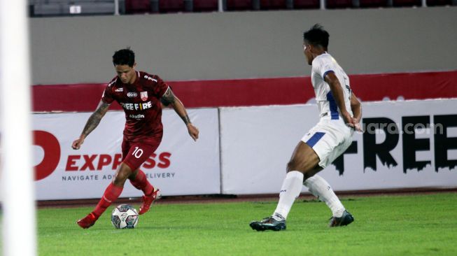 Striker Persis Solo, Irfan Bachdim berusaha berusaha melewati adangan pemain PSIM Yogyakarya, Aditya Putra Dewa dalam lanjutan Grup C Liga 2 musim 2021 di Stadion Manahan, Senin (15/11/2021). [Suara.com/Ronald Seger Prabowo]