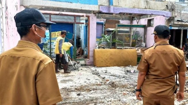 Rumah di tengah Jalan Maulana Hasanudin dibongkar petugas PUPR, Selasa (16/11/2021). [Suara.com/Muhammad Jehan Nurhakim]
