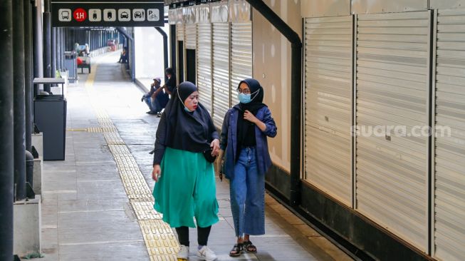 Warga melintas di depan ruko UMKM di Stasiun Gondangdia, Jakarta Pusat, Selasa (16/11/2021).[Suara.com/Alfian Winanto]