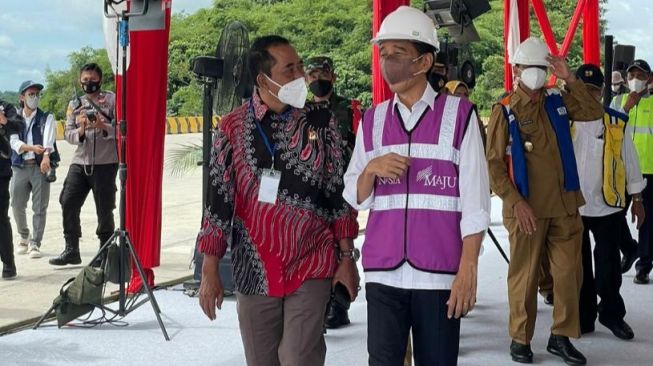 Presiden Jokowi dan Mulyadi Jayabaya berjalan berdampingan sebelum meresmikan Tol Serang-Rangkasbitung, Selasa (16/11/2021).