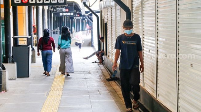 Warga melintas di depan ruko UMKM di Stasiun Gondangdia, Jakarta Pusat, Selasa (16/11/2021).[Suara.com/Alfian Winanto]