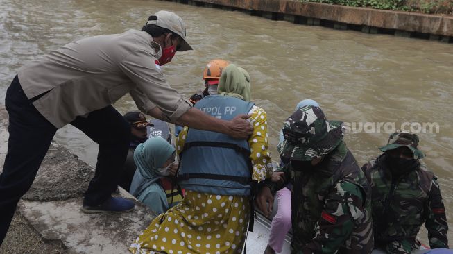 Petugas gabungan mengevakuasi korban menggunakan perahu karet saat simulasi penanganan banjir di Kalimalang, Cipinang Melayu, Jakarta, Rabu (17/11/2021). [Suara.com/Angga Budhiyanto]