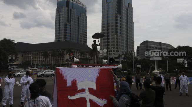 Massa yang tergabung dalam Koalisi Masyarakat Peduli Kesehatan (KOMPAK) berorasi saat menggelar aksi unjuk rasa di kawasan Patung Arjuna Wiwaha, Jakarta, Rabu (17/11/2021). [Suara.com/Angga Budiyanto]