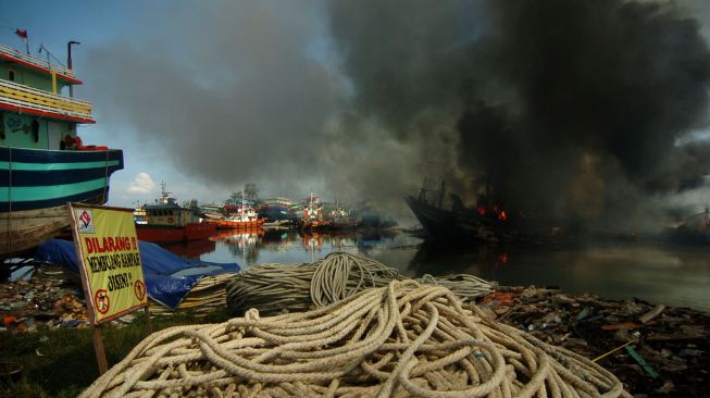 Asap mengepul dari kapal pencari ikan yang terbakar di galangan kapal Pelabuhan Tegal, Jawa Tengah, Rabu (17/11/2021). ANTARA FOTO/Oky Lukmansyah