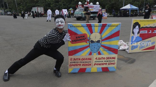 Massa, anggota Himpunan Masyarakat Terkait Kesehatan (KOMPAK), melakukan pantomim saat unjuk rasa di kawasan patung Arjuna Wiiha di Jakarta pada Rabu, 17 November 2021. [Suara.com/Angga Budiyanto]