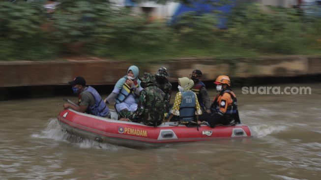 Petugas gabungan mengevakuasi korban menggunakan perahu karet saat simulasi penanganan banjir di Kalimalang, Cipinang Melayu, Jakarta, Rabu (17/11/2021). [Suara.com/Angga Budhiyanto]