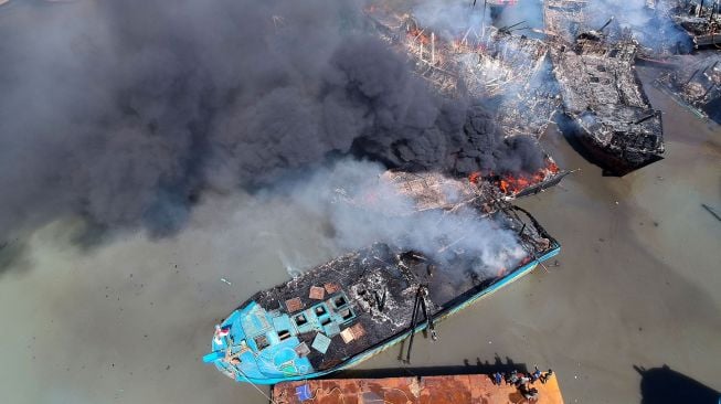 Foto udara kapal pencari ikan yang terbakar di galangan kapal Pelabuhan Tegal, Jawa Tengah, Rabu (17/11/2021). ANTARA FOTO/Oky Lukmansyah