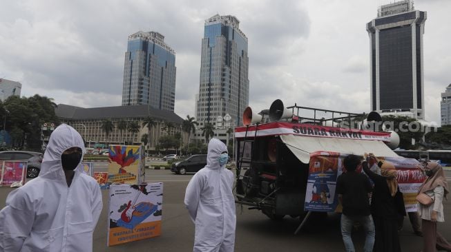 Polisi berhazmat berjaga saat unjuk rasa yang digelar oleh Koalisi Masyarakat Peduli Kesehatan (KOMPAK) di kawasan Patung Arjuna Wiwaha, Jakarta, Rabu (17/11/2021). [Suara.com/Angga Budiyanto]