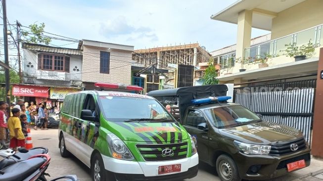 Penampakan ambulans yang dikerahkan ke lokasi robohnya bangunan SMAN 96 yang roboh saat direnovasi. Empat pekerja jadi korban karena tertimpa reruntuhan bangunan. (Suara.com/Yaumal)