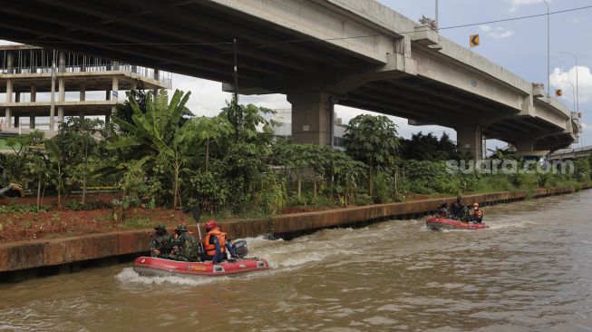 Petugas gabungan menggunakan perahu karet untuk mengevakuasi korban saat simulasi penanganan banjir di Kalimalang, Cipinang Melayu, Jakarta, Rabu (17/11/2021). [Suara.com/Angga Budhiyanto]