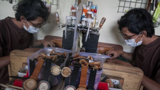 Perajin menyelesaikan pembuatan jam tangan kayu berbahan limbah papan skateboard di Bengkel Loosewood, Banjarsari, Solo, Jawa Tengah, Rabu (17/11/2021).  ANTARA FOTO/Mohammad Ayudha
