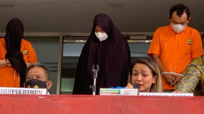 Riri Khasmita (berhijab) menatap sinis ke arah Nirina Zubir, saat dihadirkan oleh Polda Metro Jaya, Kamis (18/11/2021). [Evi Ariska/Suara.com]